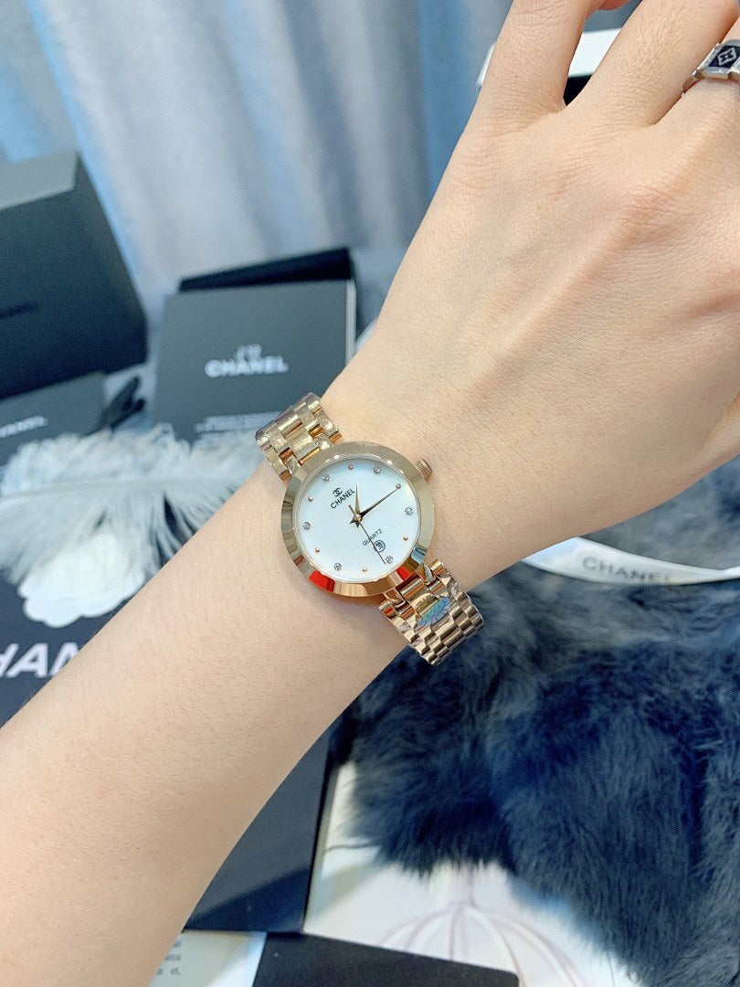Chanel watch close-up on wrist, round silver dial and gold-tone metal bracelet