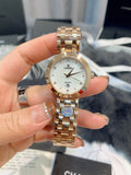 Chanel watch with round silver dial, gold-tone metal bracelet, quartz markers
