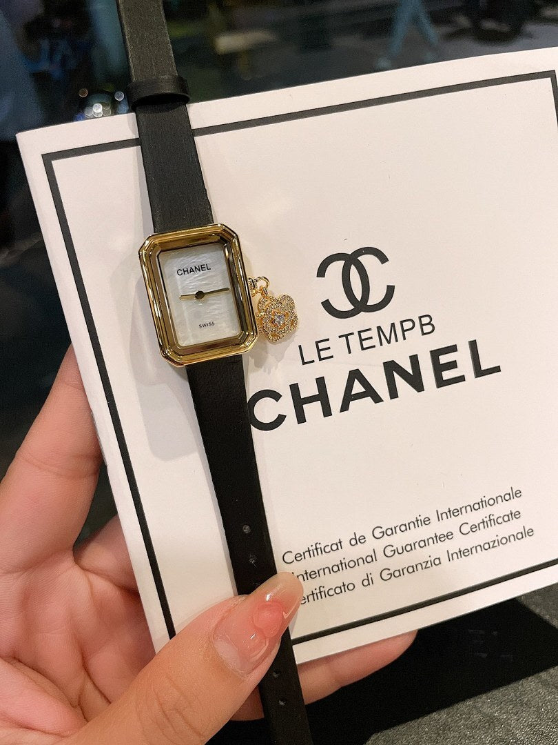 Chanel watch on black leather strap with gold-tone case and certificate card