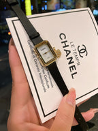 Chanel watch close-up with dark dial, gold-tone case, and black leather strap