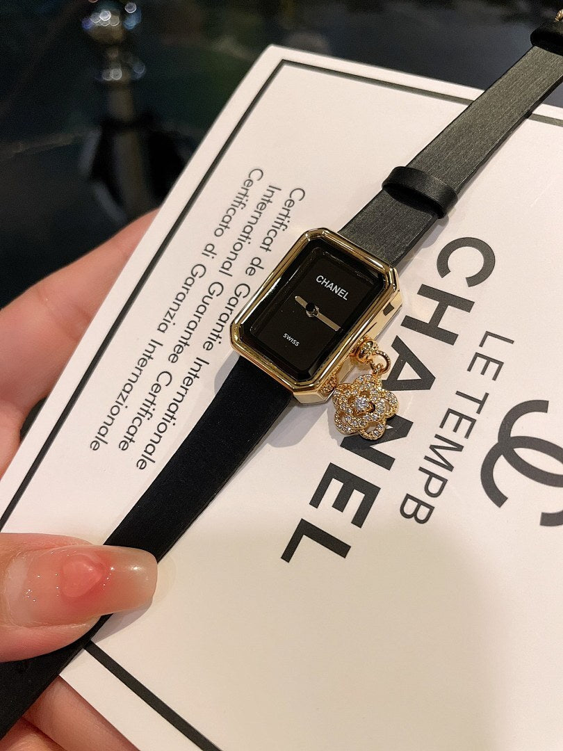Chanel watch with dark dial and gold-tone case on black leather strap
