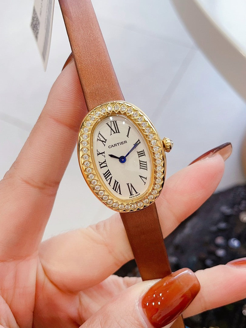 Oval wrist watch with tan leather strap, jeweled bezel, Roman numeral dial, blue hands