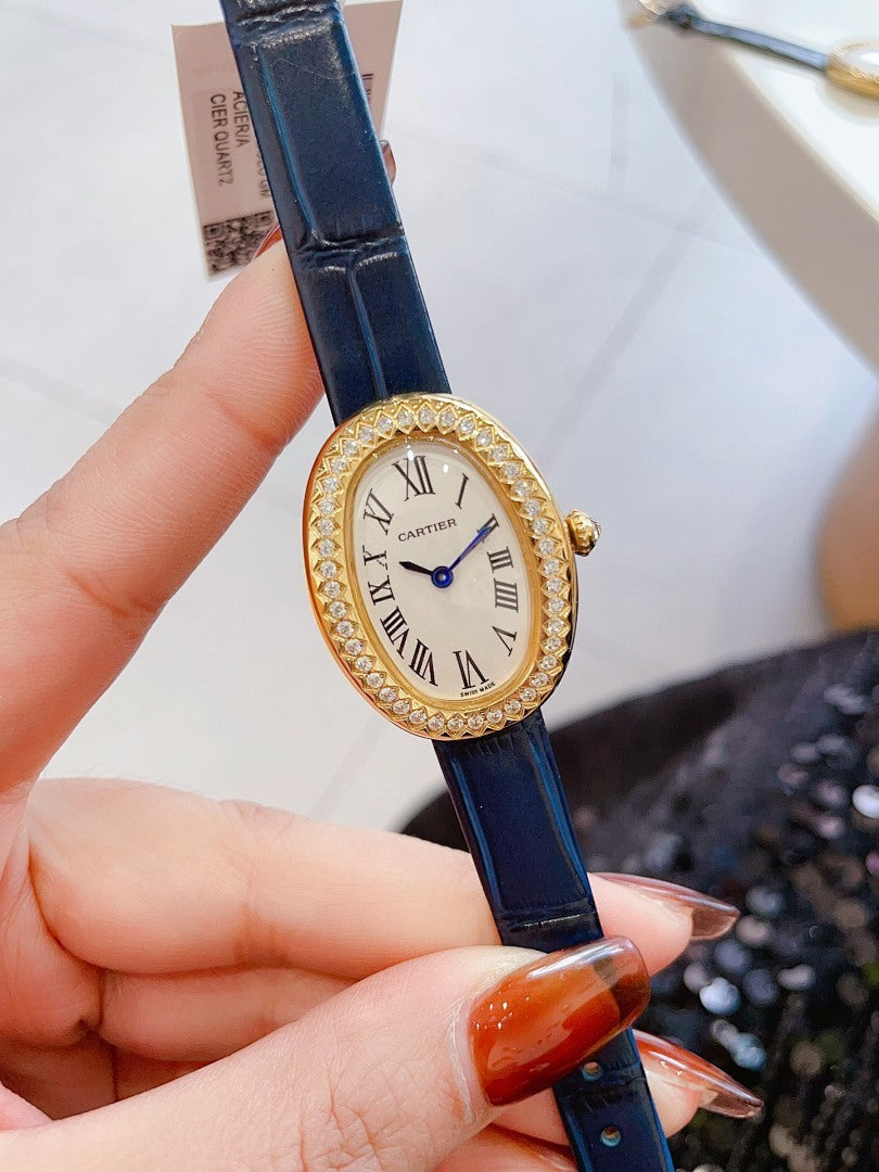 Oval wrist watch with dark blue leather strap, jeweled bezel, Roman numeral dial, blue hands