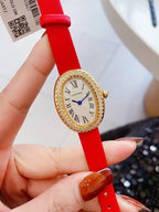 Oval wrist watch with bright red leather strap, jeweled bezel, Roman numeral dial, blue hands
