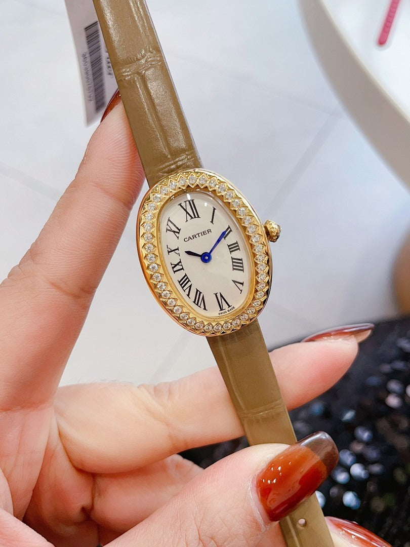 Oval wrist watch with brown leather strap, jeweled bezel, Roman numeral dial, blue hands