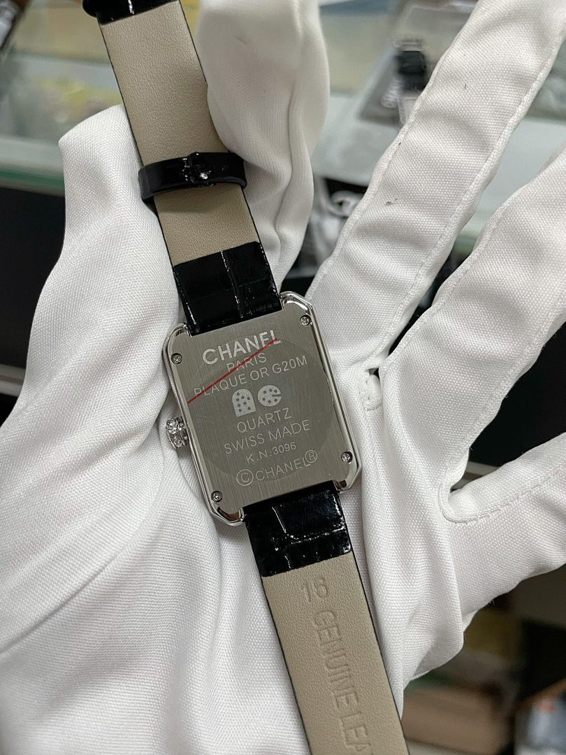 Chanel watch with black leather strap, silver back plate engraved “SWISS MADE”.