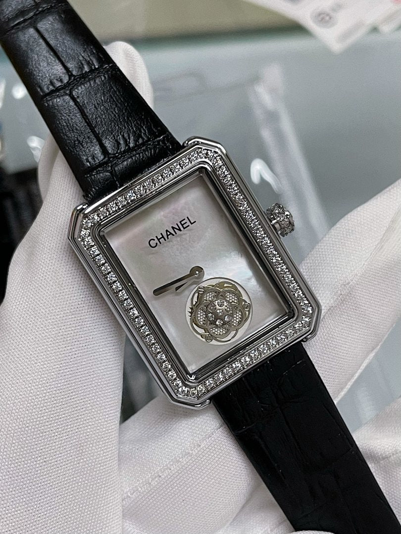 Square watch face with black leather strap, silver rhinestone bezel, crown on right