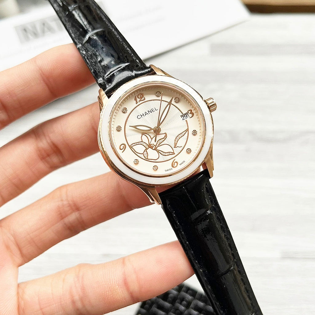 Chanel watch with black leather strap and gold-tone bezel, round floral butterfly dial