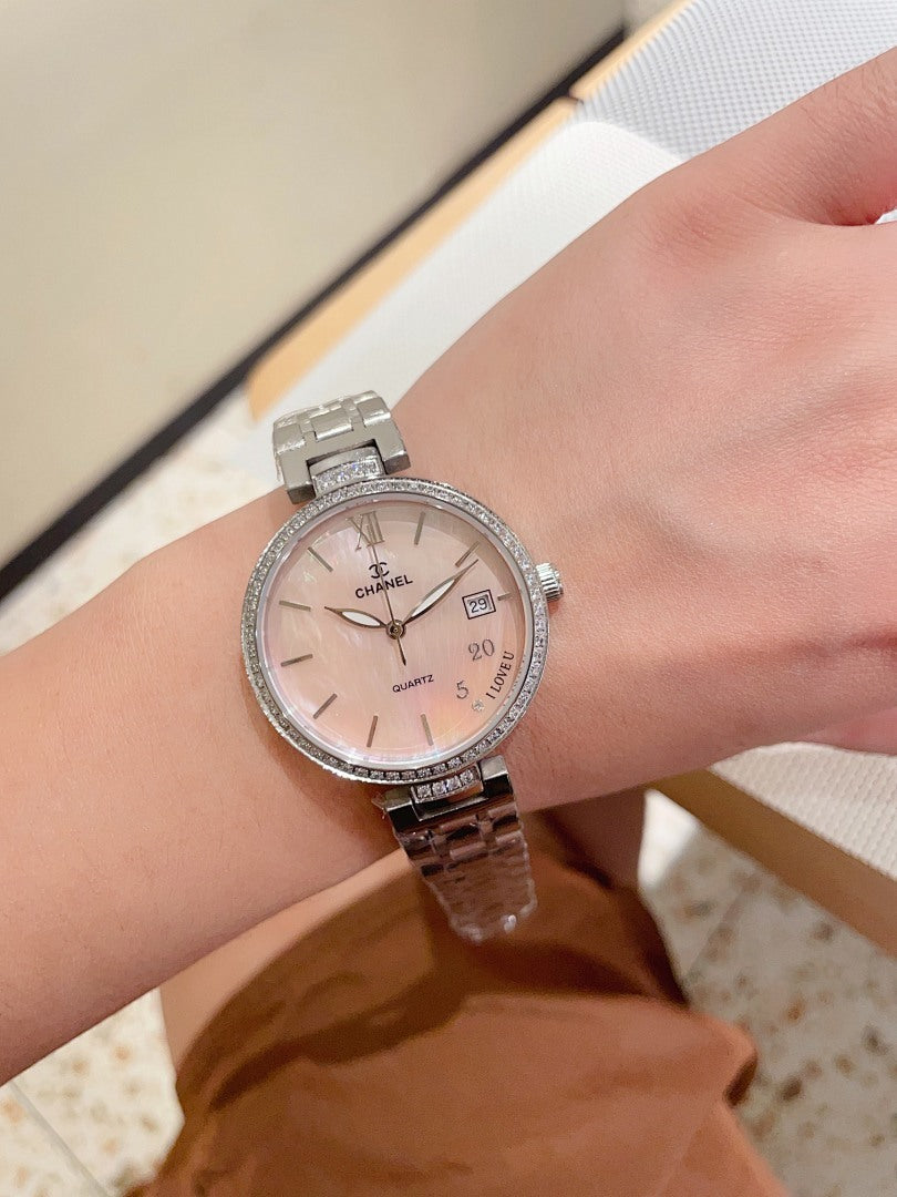 Silver-tone Chanel wrist watch on wrist, round white dial with Roman numerals