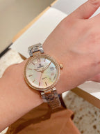 Gold-tone Chanel wrist watch with metal bracelet, round white dial and Roman numerals