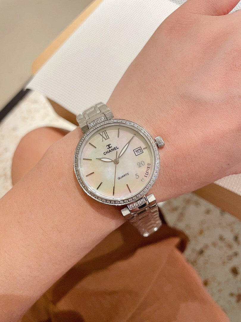 Silver-tone Chanel wrist watch with jeweled bezel, round white dial and Roman numerals