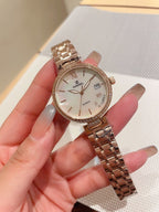 Gold-tone Chanel wrist watch with metal bracelet, round white dial and Roman numerals