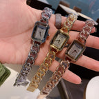 Chanel watch set with silver and gold rectangular dials and link chains held in hand