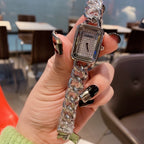 Chanel watch with silver chain and rectangular dial, held in hand
