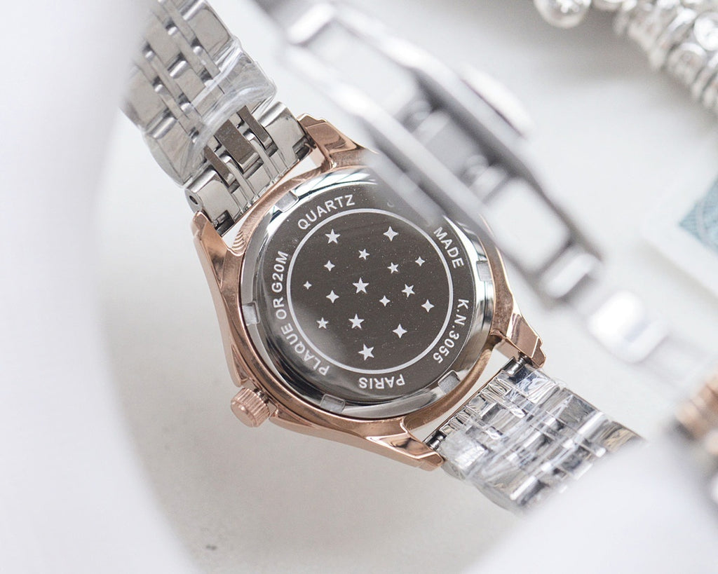 Metal analog wristwatch with engraved case back and patterned bezel
