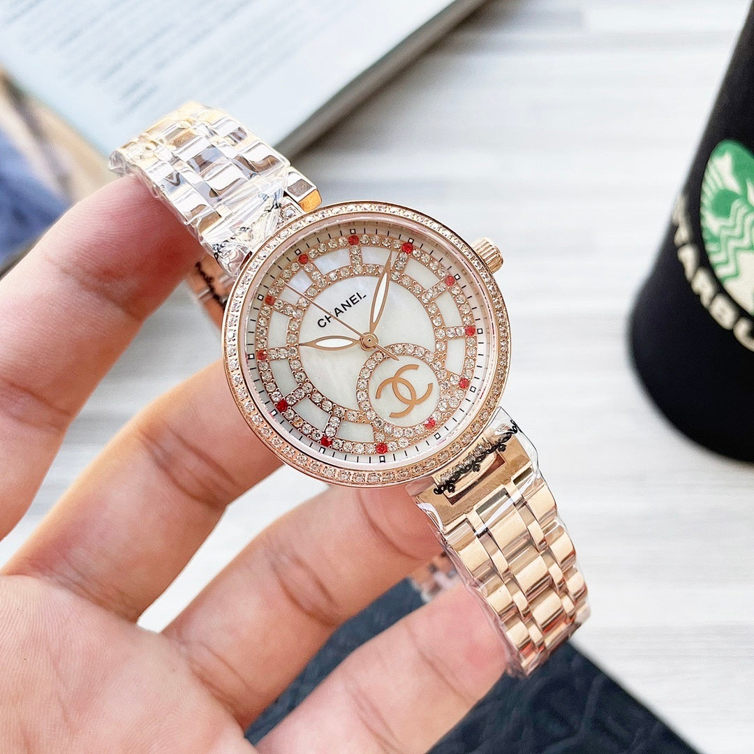 Rose-gold CHANEL round watch with jeweled bezel, white dial with red/blue markers and metal bracelet