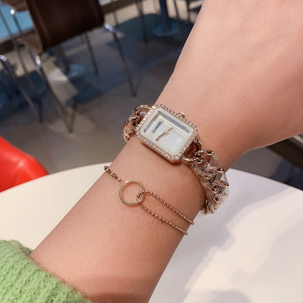 Rectangular pale-dial watch with gold-toned chain bracelet and rhinestone bezel