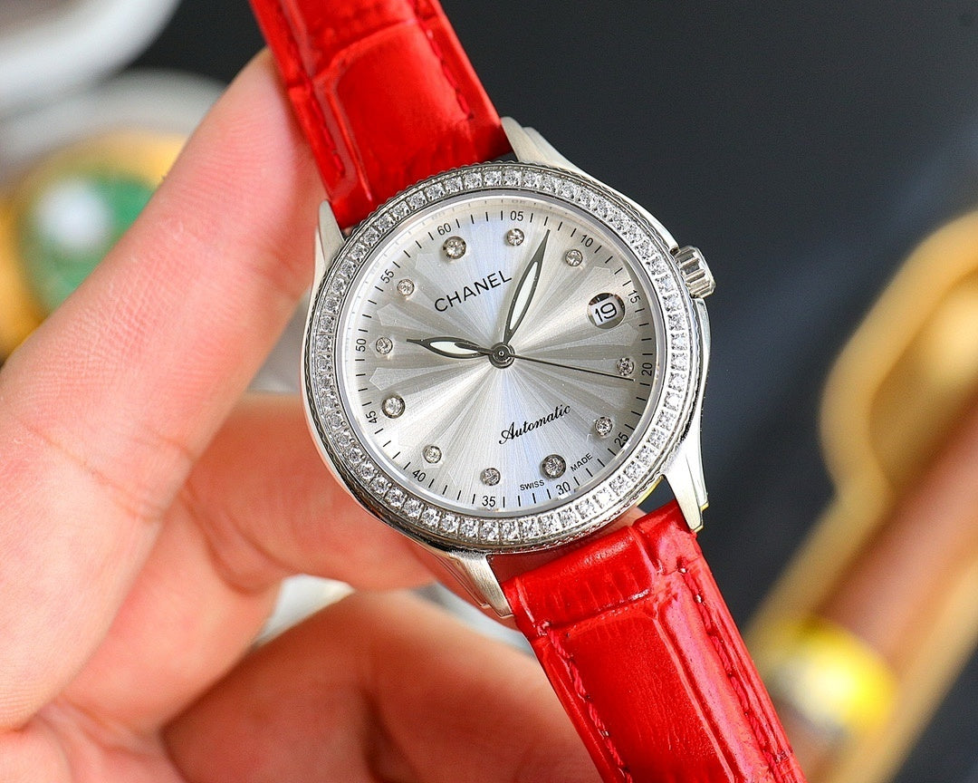 Chanel watch with round silver face, jeweled bezel, and red leather strap