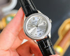 Chanel watch with round silver dial, jeweled bezel, and black leather strap