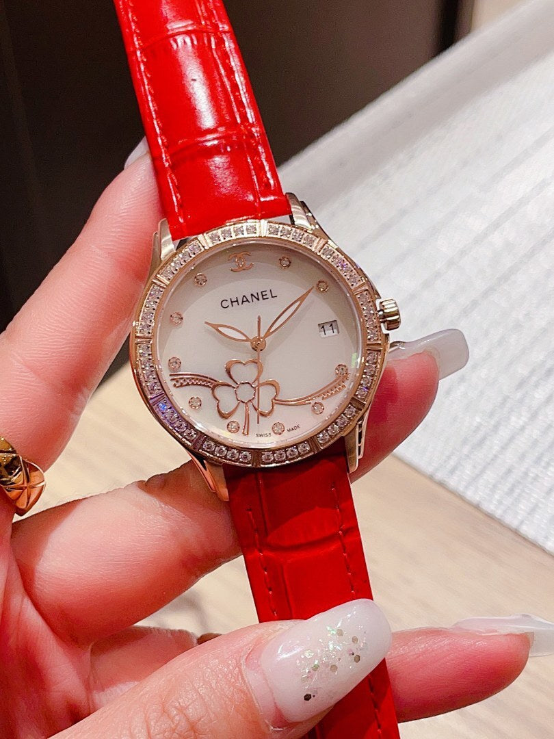 Chanel watch with jeweled bezel, red leather strap, round white floral dial.