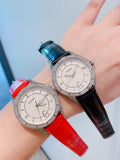 Chanel watches with jeweled bezels, blue and red leather straps, round white dials.