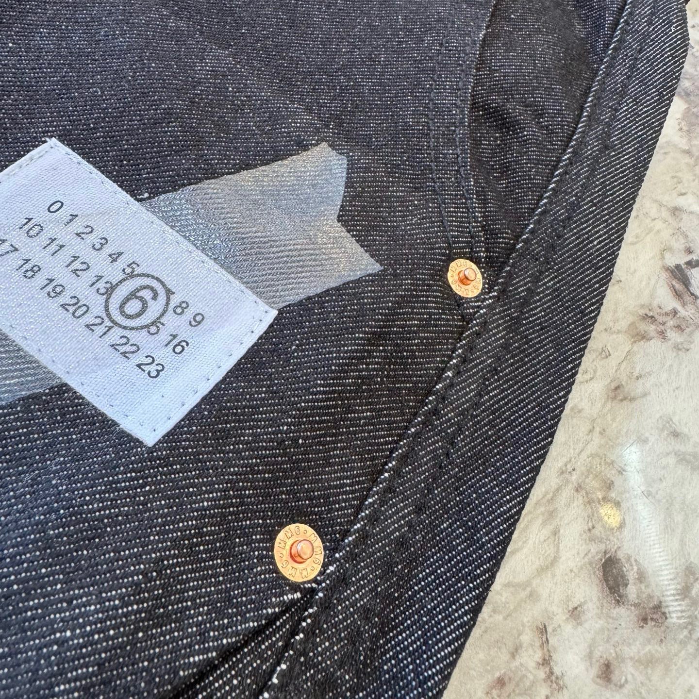 Dark denim shorts close-up of snap buttons at waist and size label