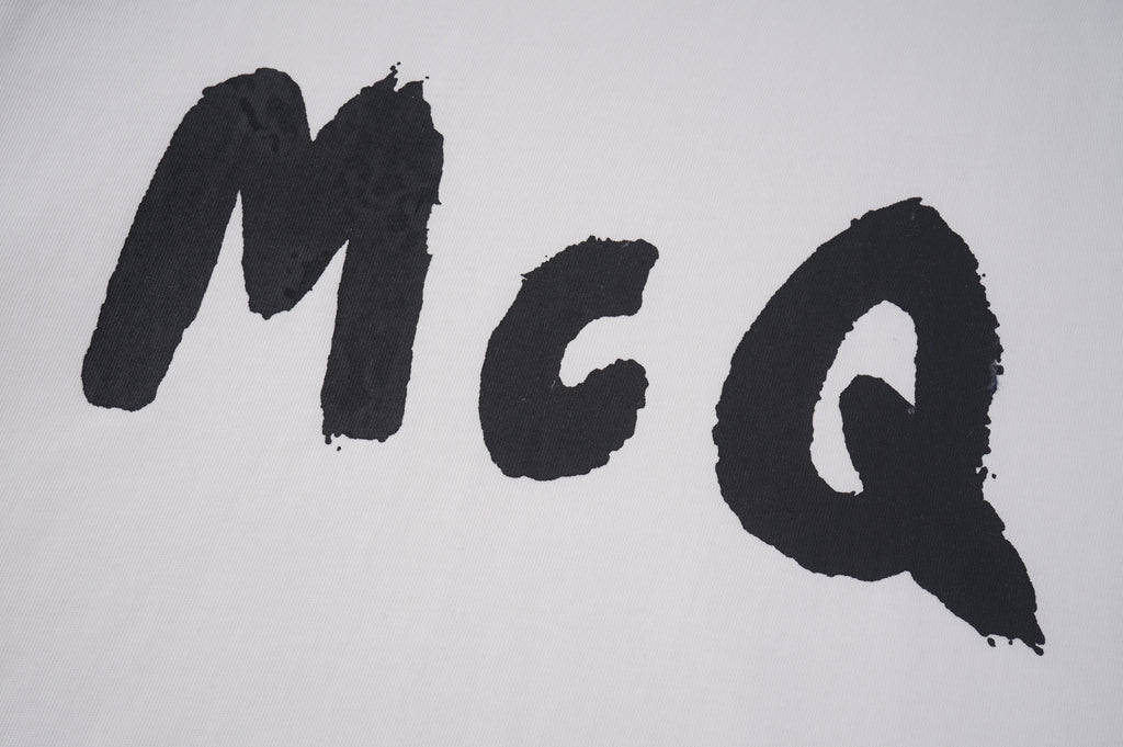Alexander McQueen T-shirt close-up, large black McQ letters on light fabric
