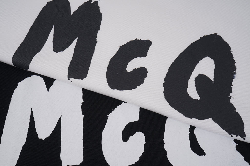 Alexander McQueen T-shirt close-up, black McQ letters on light fabric