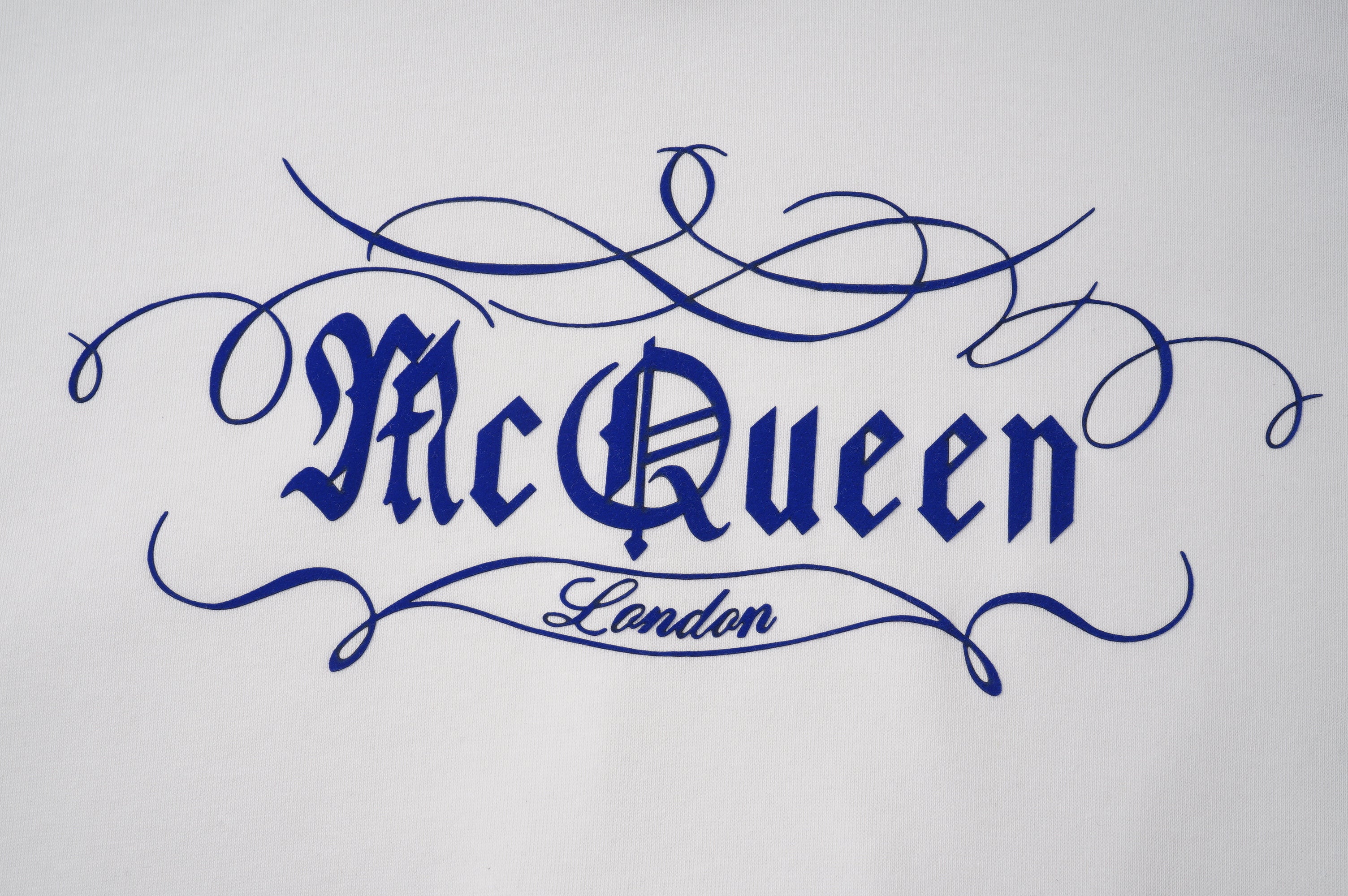 Light hoodie fabric with blue embroidered 'McQueen' logo and 'London' detail