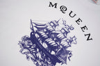 White T-shirt close-up with blue pirate ship graphic and curved McQueen letters