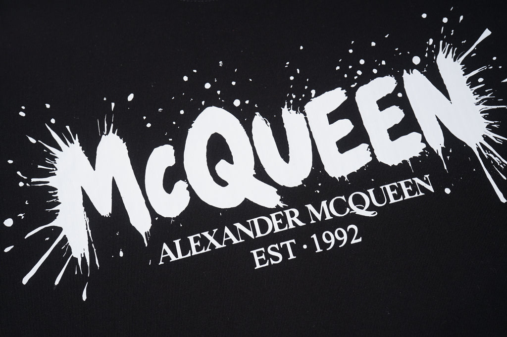Black T-shirt with large McQueen logo and splatter-style print