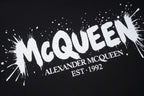 Black T-shirt with large McQueen logo and splatter-style print