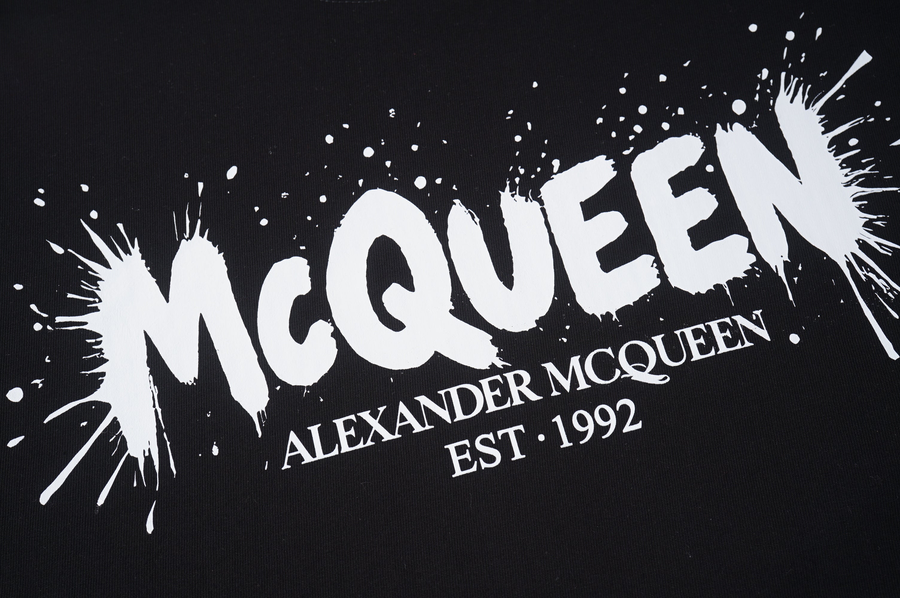 Black T-shirt with large McQueen logo and splatter-style print