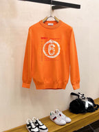 Orange crewneck sweatshirt with long sleeves and “6” graphic print on chest