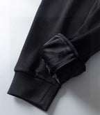 Dark long-sleeve top with ribbed cuff and folded sleeve detail