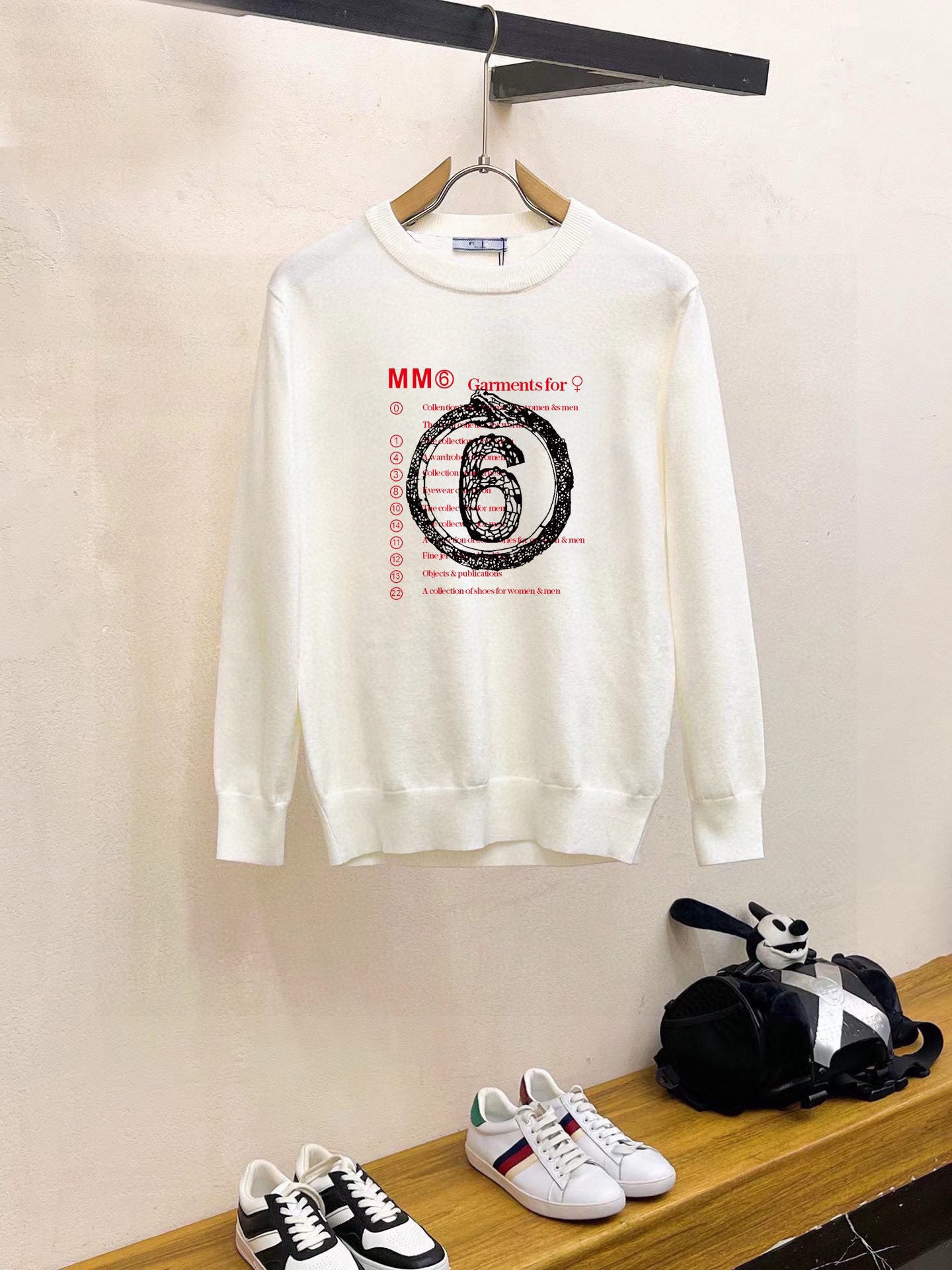 White crewneck sweatshirt with long sleeves and “6” graphic print on chest