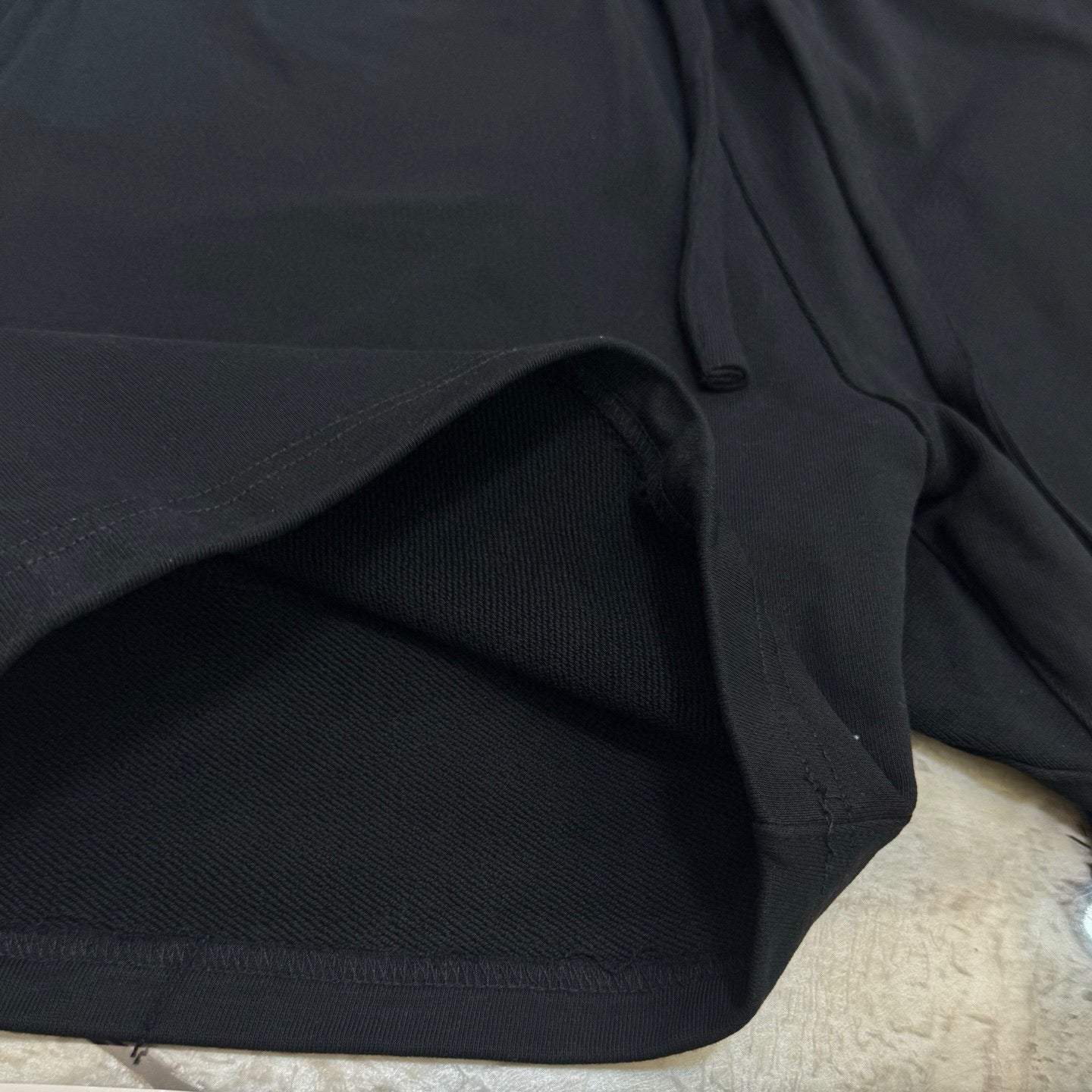 Black shorts fabric close-up with stitched drawstring waist