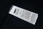 Black T-shirt care label with MM6 garment information tag