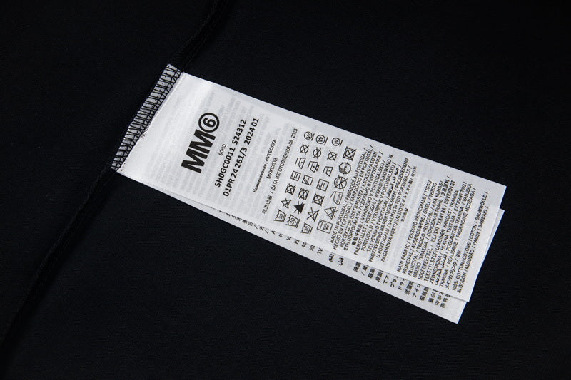 Black T-shirt care label with MM6 garment information tag
