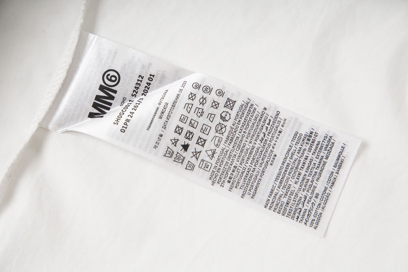 White shirt care label with icons on inner seam