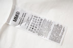 White shirt care label with “MMO” and washing instructions