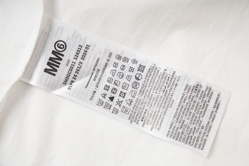 White shirt care label with “MMO” and washing instructions