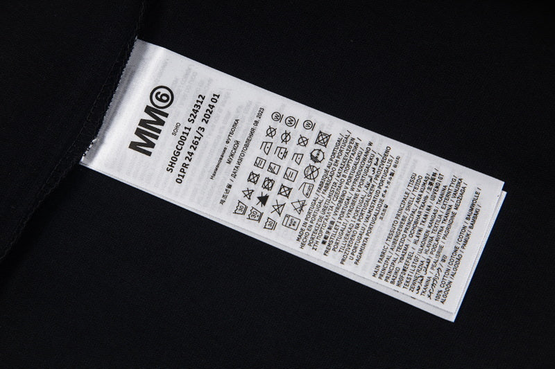 Black T-shirt with interior neck label and care symbols, sleeve edge visible.