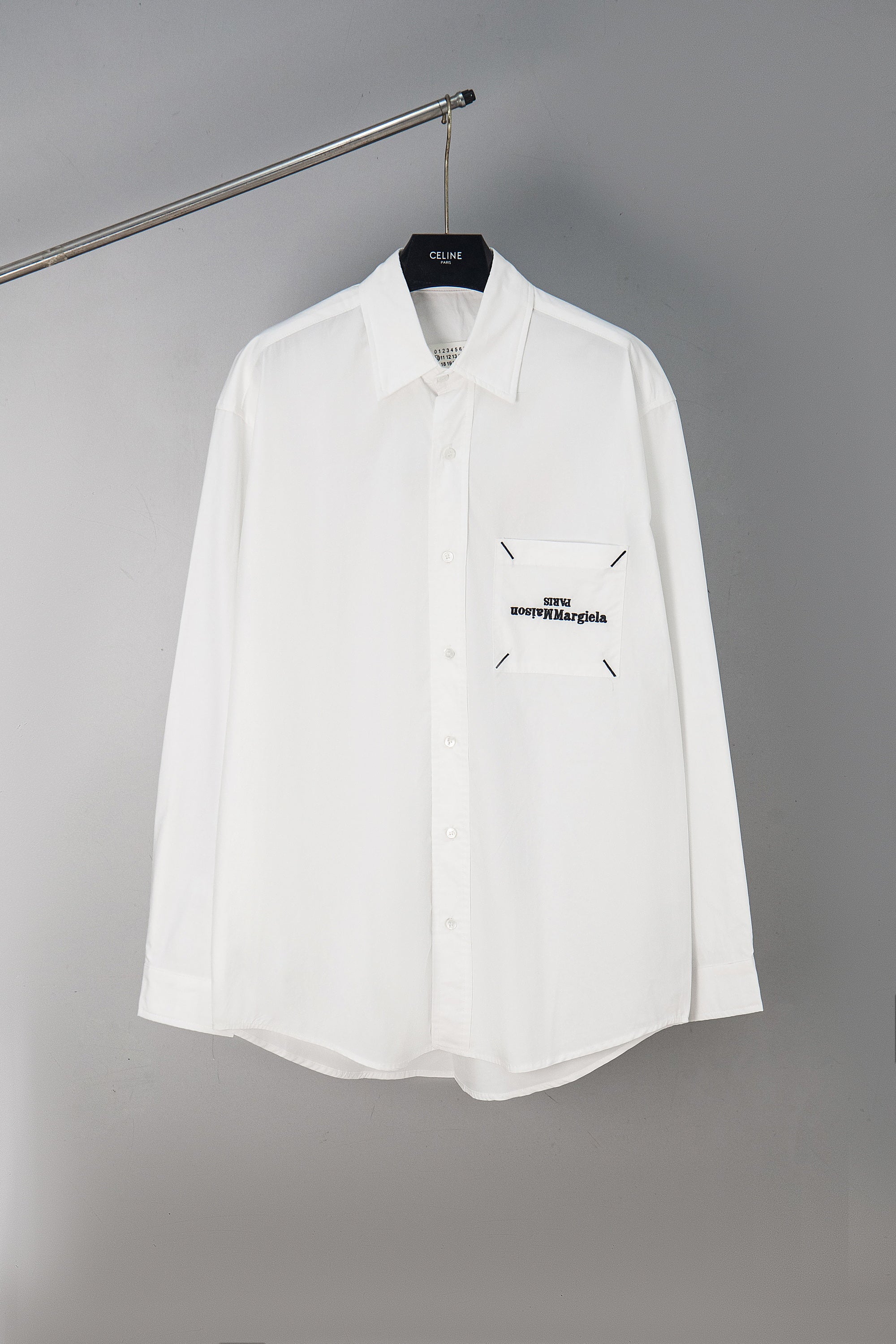 White button-up shirt with chest pocket and small Maison Margiela logo