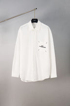 White button-up shirt with pointed collar and chest logo detail