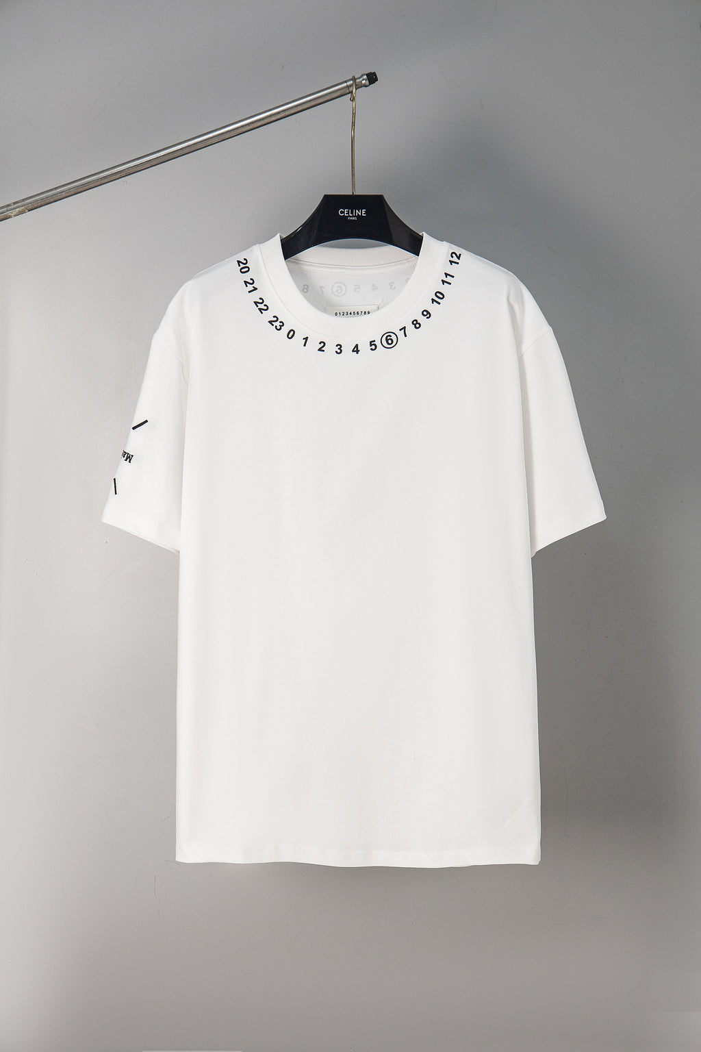 White crewneck T-shirt with number graphic around neckline, short sleeves.