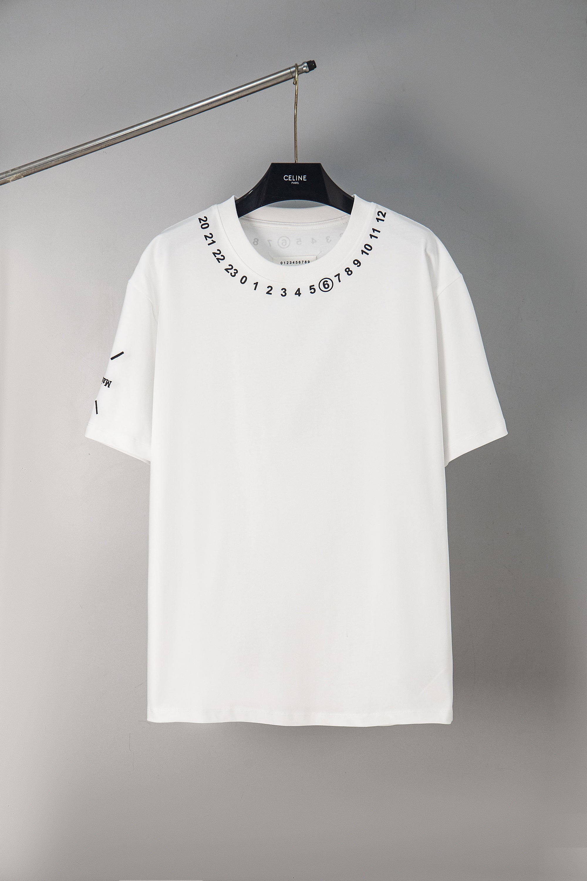White crewneck T-shirt with number graphic around neckline, short sleeves.