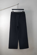 Dark wide-leg trousers with elastic waistband and front crease
