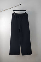 Dark wide-leg trousers with elastic waistband and front crease