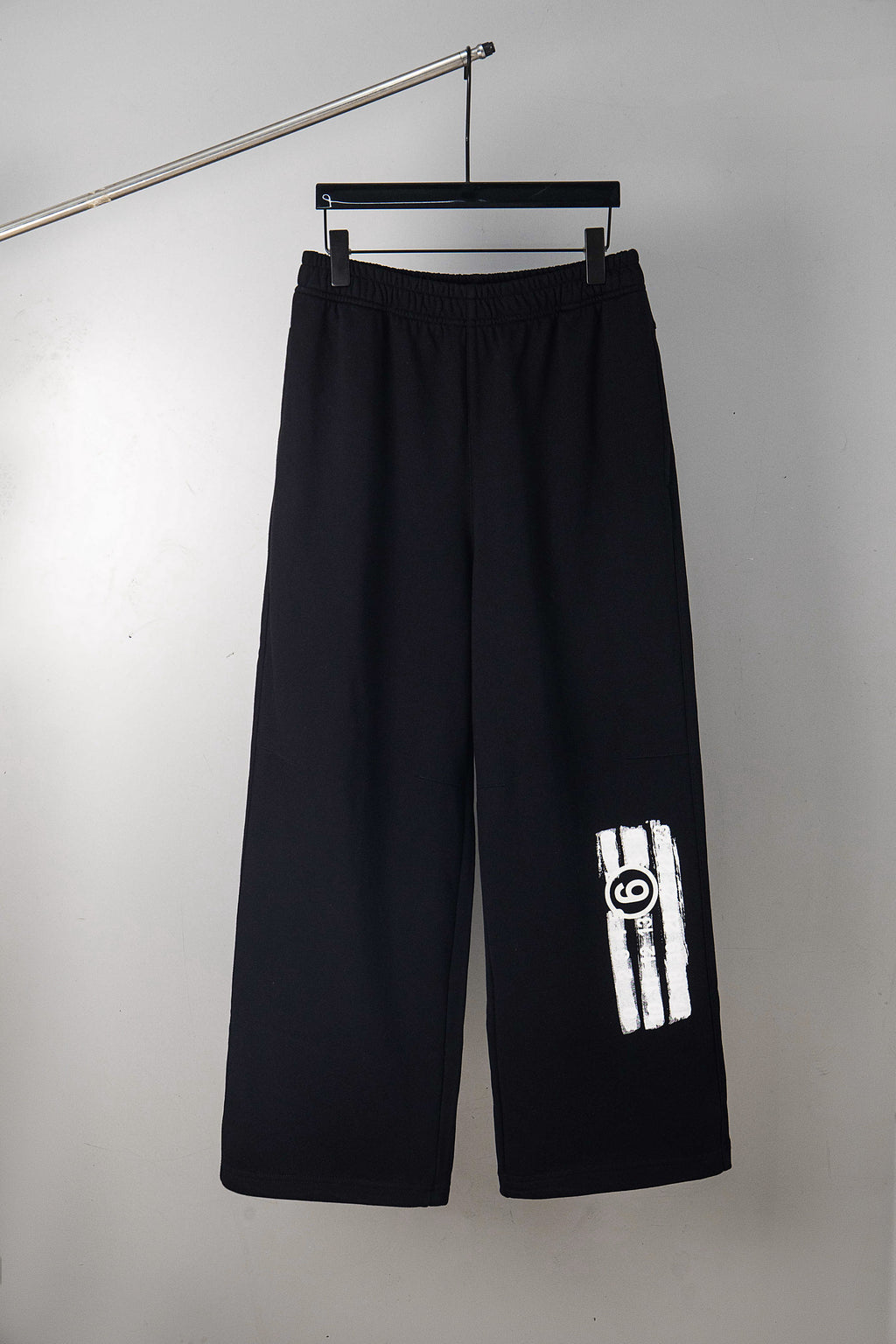 Black wide-leg pants with side logo patch on the right leg